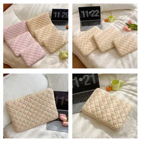 Detailed view of cozy quilted laptop sleeve, floral strawberry pattern, soft protective case.