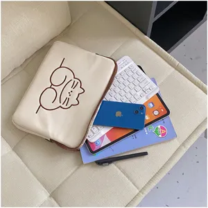 Detail view of cute cat style ipad tablet sleeve bag, soft fabric lifestyle flat lay setup.