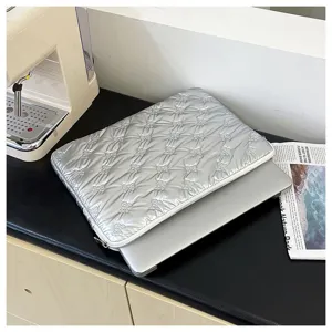 Vista di dettaglio della custodia per laptop trapuntata argentata con fiocco carino.