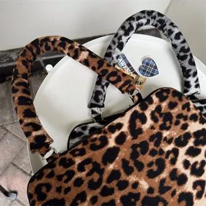 Primo piano dettagliato di una custodia per laptop alla moda con stampa leopardata e maniglie.