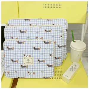 Detailansicht der blau karierten Laptoptasche mit süßem Welpenmuster und weichem Innenfutter.