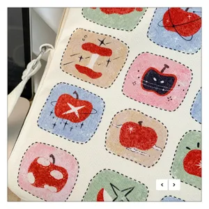 Dettaglio custodia iPad in tela con stampa mela, elegante borsa per laptop con manico.
