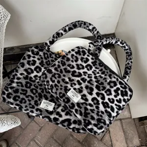 Custodia per laptop grigia con stampa leopardata, texture soffice e manici imbottiti.