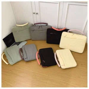 Detailed view of multi-color laptop sleeves with wave patterns and padded handles on wood floor.
