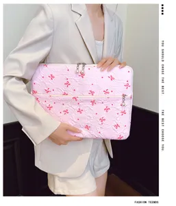 Détail de housse pour ordinateur rose matelassée avec jolis nœuds brodés et perles fines.