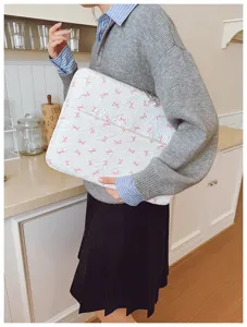 Housse pour ordinateur portable blanche matelassée avec nœuds roses et perles élégantes.