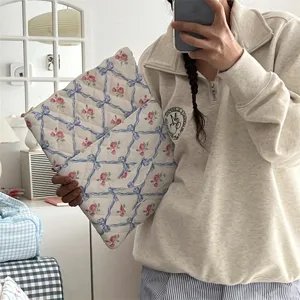 Quilted floral laptop sleeve with blue bow design, aesthetic tablet storage bag for women.