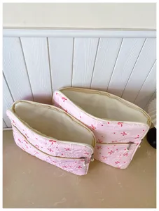 Housse pour ordinateur portable rose plissée avec nœud rouge et fermeture en perle.
