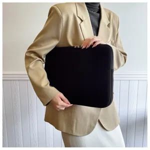 Nahaufnahme einer schwarzen Laptopschutzhülle, präsentiert von einem Model im Blazer.