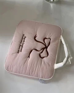 Nahaufnahme der rosa gesteppten Laptoptasche mit brauner Stickerei einer Schleife und Text.