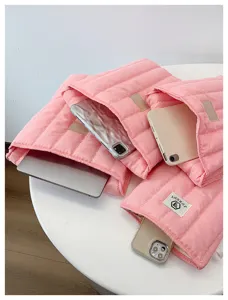 Pink quilted laptop sleeve close-up, soft cotton protective pouch for portable electronic devices.
