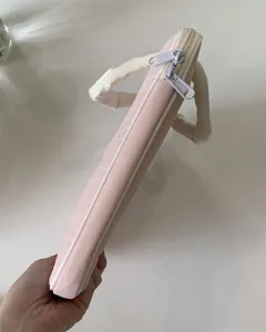 Rosa gesteppte Laptoptasche Detailansicht mit glatten Doppelreißverschlüssen und Griffen.