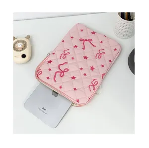 Pink quilted laptop sleeve detail, cute bow and star embroidery, soft tablet storage bag interior view.