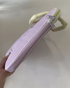 Nahaufnahme der süßen bestickten Laptoptasche mit doppelten Reißverschlüssen und Griffen.