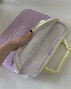 Detailansicht einer süssen lila Laptoptasche mit Henkeln und englischer Stickerei.