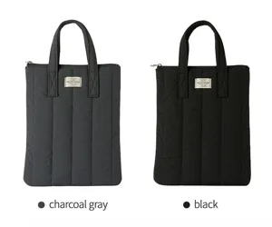 Padded laptop bag detail, vertical quilted puffer design, dual top handles, secure zip closure.