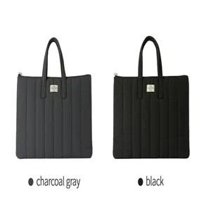 Quilted laptop tote bag detail view, 13-inch padded tablet sleeve, dual top handles.