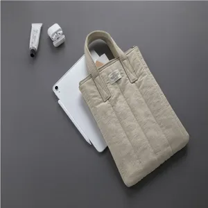 Quilted laptop sleeve handbag with handles, soft padded tablet case for 11 to 13 inch devices.