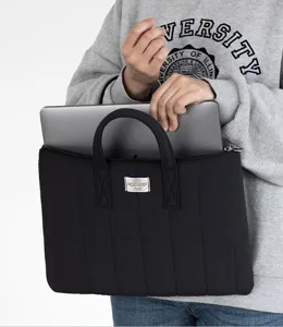 Detail shot of the black quilted laptop sleeve with dual handles, ideal for 13-inch devices.