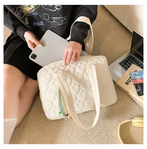 Dettaglio della borsa shopper trapuntata a cuore beige, che mostra la grande capacità.