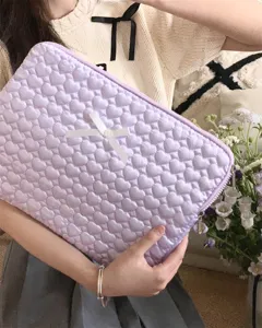 Close-up detail of the quilted light purple laptop sleeve with cute heart pattern and bow.