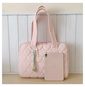 Vista dettagliata della borsa tote trapuntata rosa con motivo a cuore, trama e formato tablet.
