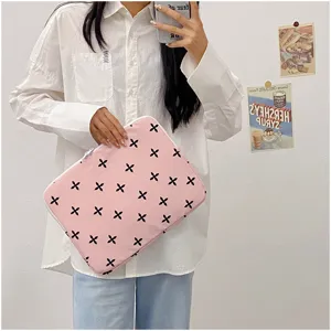 Detailed shot of a cute pink laptop sleeve with black cross pattern, soft fabric material.