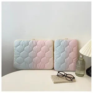 Detailed shot of cute gradient quilted laptop sleeve, pastel colors on white desk setup.