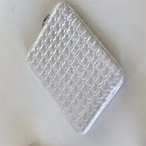 White quilted heart laptop sleeve detail, soft fabric and secure zipper for daily use.