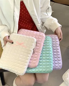 Detail view of the quilted heart pattern tablet sleeve featuring a cute bow in pastel colors.