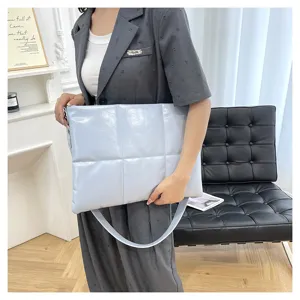Quilted puffy laptop bag detail, soft space cotton material, elegant light blue shoulder bag.
