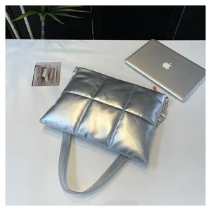Silver quilted puffy laptop bag detail showcasing soft metallic fabric texture and design.