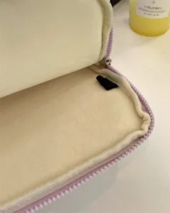 Purple plush laptop sleeve interior detail, soft lining and zipper structure for protection.