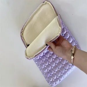 Quilted heart tablet sleeve, soft inner lining, zipper closure, detail view of the laptop bag.