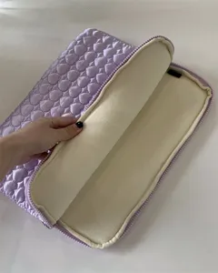 Detailed view of a purple quilted cute peach heart laptop sleeve with plush inner lining.