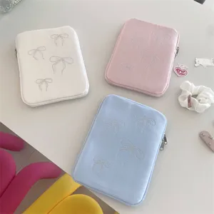 Detailed shot of cute bow rhinestone tablet sleeve, soft pastel colors, protective laptop bag.