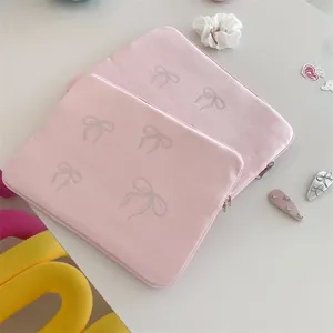 Pink velvet laptop sleeve with sparkling rhinestone bows for cute aesthetic protection.