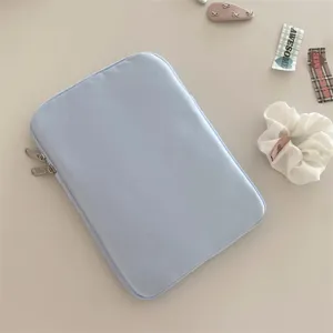 Light blue minimalist laptop sleeve and tablet pouch with secure zipper closure for daily use.