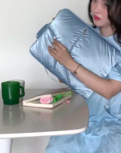 Detailed view of the stylish light blue quilted laptop bag for women, portable design.