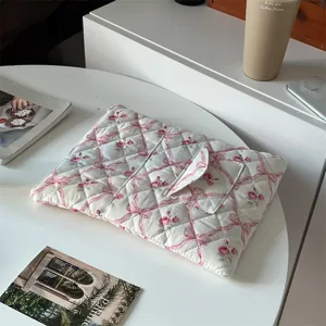 Close-up detail of quilted floral laptop sleeve with cute bow pattern and pocket.