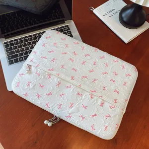 Jolie housse de protection pour ordinateur portable avec nœuds brodés et fermeture éclair en perles.