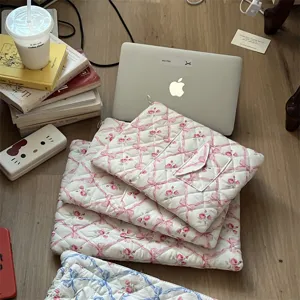 Quilted laptop sleeve featuring a charming floral and bow pattern, soft padded tablet storage bag.