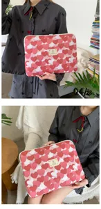 Detail de housse d'ordinateur en peluche avec motif de coeur rose et texture douce.