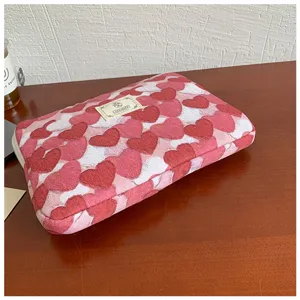 Détail de housse d'ordinateur à motif de cœur rose, sac de protection pour tablette et PC.