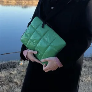 Primo piano dettagliato della custodia trapuntata verde per laptop con morbida imbottitura.