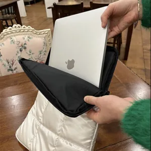 Primo piano dettagliato di una custodia per laptop trapuntata bianca in fase di utilizzo.