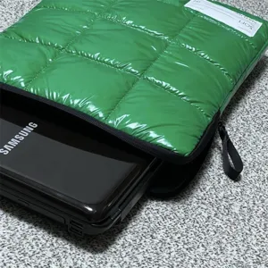 Dettaglio custodia per laptop trapuntata verde, morbida borsa imbottita vista ravvicinata.