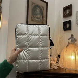 Dettaglio custodia per laptop trapuntata argentata, borsa protettiva morbida in cotone.