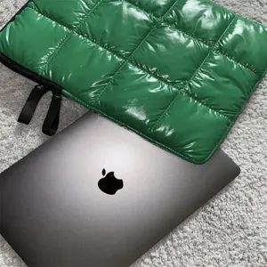 Vista dettagliata della custodia trapuntata verde per laptop, protezione imbottita.