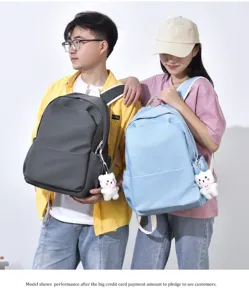 Vista detallada de la mochila para estudiantes de color liso con bonito colgante de oso.